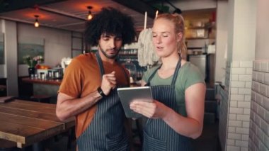 Kahve dükkanında çalışırken iki genç adam ve kadının dijital tablet kullanırken çekilmiş.
