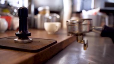 Barista kahve yapmak için portatif filtreye kahve sıkıştırıyor.