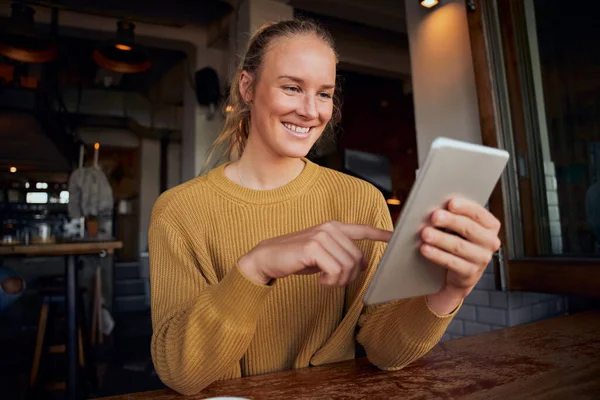 Mulher usando tablet digital sentado e relaxante no café moderno — Fotografia de Stock