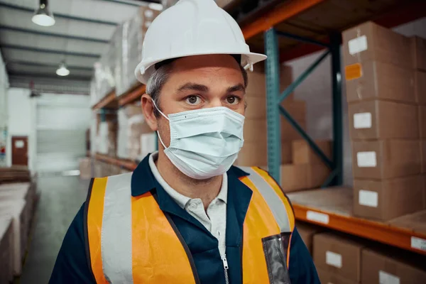 Egy ipari raktárban biztonsági maszkos férfi gyári munkás közelképe — Stock Fotó