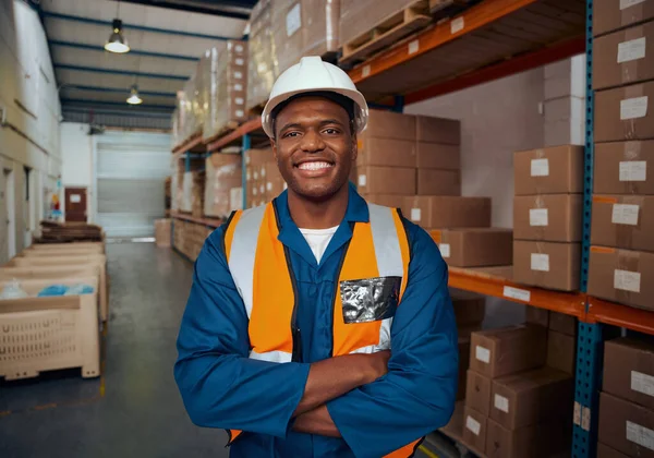 Portret van een zelfverzekerde Afrikaanse fabrieksingenieur met zijn arm gekruist in een groot magazijn — Stockfoto