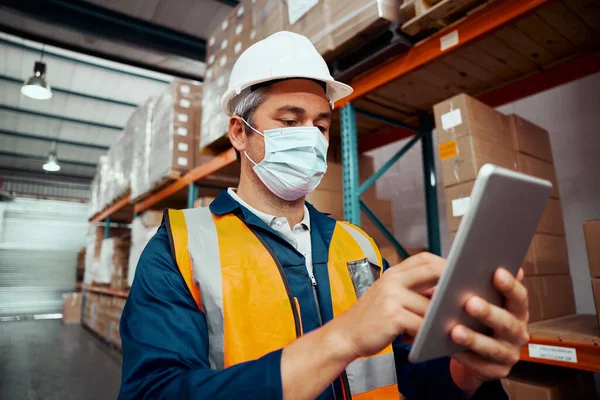 Operaio di fabbrica maschile che utilizza tablet digitale con maschera protettiva al magazzino — Foto Stock