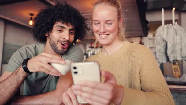 Homem bebendo café olhando para amigo feminino usando telefone inteligente no café — Vídeo de Stock