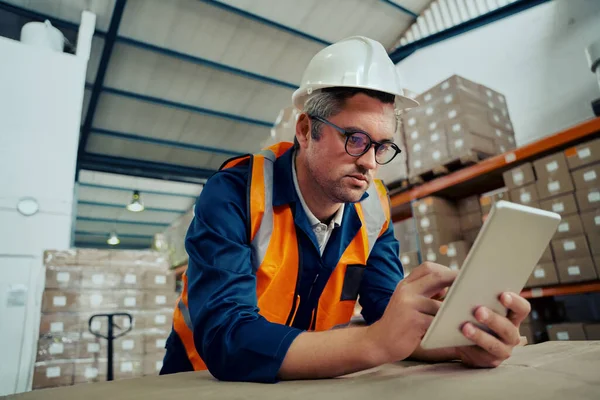 Ingegnere di fabbrica maschile che indossa occhiali utilizzando tablet digitale appoggiato sul tavolo — Foto Stock