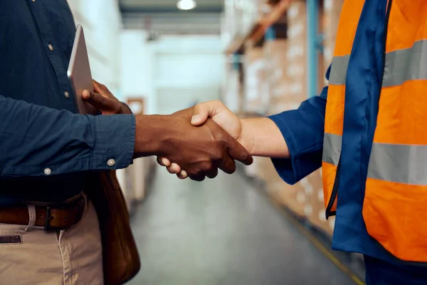 Visão do meio de dois trabalhadores do sexo masculino apertando as mãos na fábrica — Fotografia de Stock