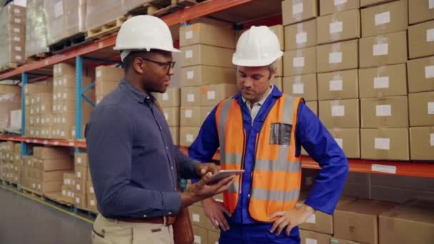 Trabalhador masculino multiétnico e gerente apertar as mãos juntos após a discussão usando tablet digital em grande armazém de distribuição — Vídeo de Stock