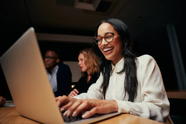 Close-up de bem sucedida sorridente jovem empresária afro-americana sentado perto de colegas de trabalho usando laptop no escritório — Fotografia de Stock