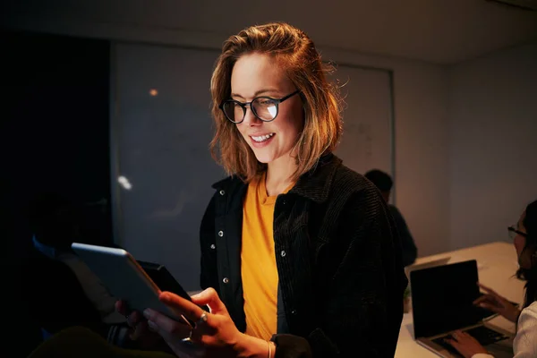 Retrato de uma jovem mulher de negócios sorridente usando tablet digital no escritório moderno — Fotografia de Stock