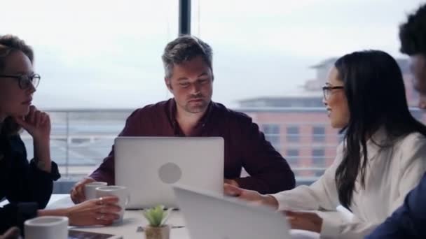 Diverse group of colleagues discussing brief for new collaboration project holding paper work typing on laptop brainstorming ideas — Stock Video