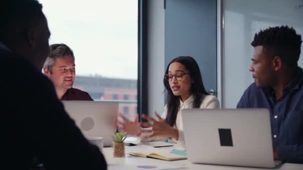 Gemengde race zakenvrouw leidende presentatie van de korte voor nieuw project met collega 's zitten op kantoor typen notities op laptop — Stockvideo