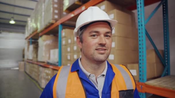 Retrato del trabajador de almacén caucásico de mediana edad sonriente en un gran centro de distribución de almacén — Vídeos de Stock