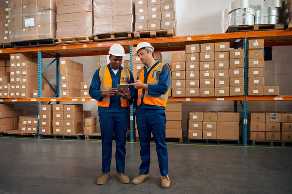 Trabajador de fábrica masculino multirracial comprobando los pedidos en tableta digital en gran almacén — Foto de Stock