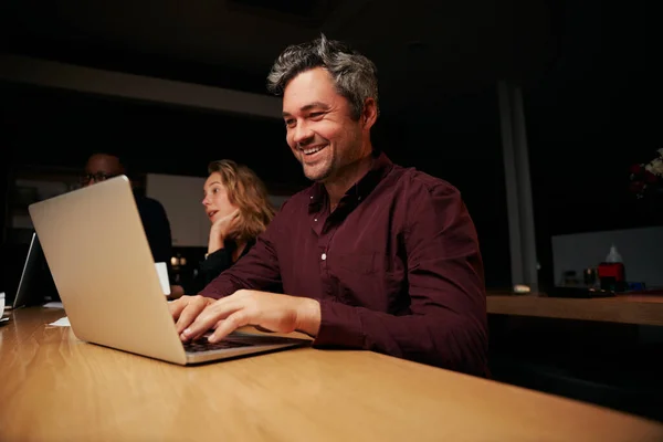 Portret van een succesvolle middelbare leeftijd zakenman typen op laptop op het werk — Stockfoto