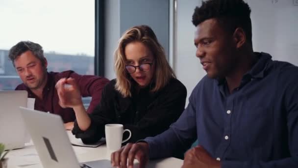 Mulher de negócios caucasiana sentindo-se estressada trabalhando com colegas do sexo masculino em projeto de digitação no laptop — Vídeo de Stock