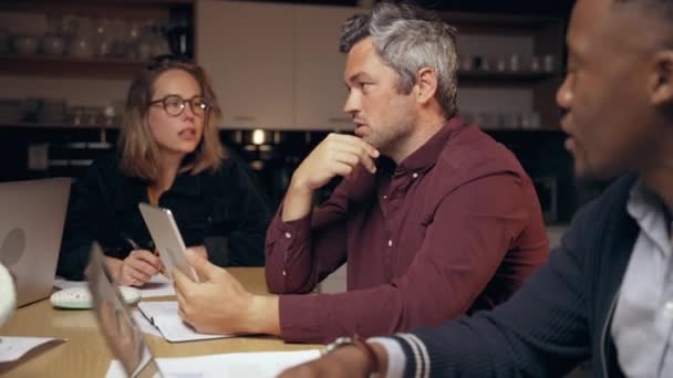 Hombre de negocios caucásico instruyendo reunión con colegas que trabajan hasta tarde en la noche terminando breve para el nuevo proyecto de colaboración — Vídeo de stock