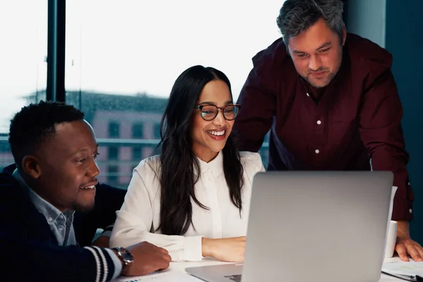 Jovem e bem sucedido grupo diversificado de empresários trabalhando juntos em um laptop no escritório moderno — Fotografia de Stock