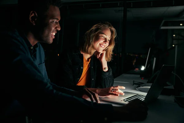 Diversos empresários criativos que trabalham com laptop horas extras à noite em pouca luz no escritório — Fotografia de Stock