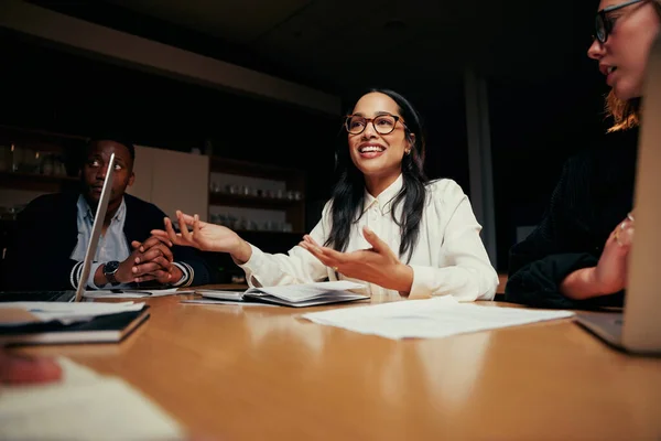 Portrait d'une jeune femme d'affaires souriante discutant avec son collègue lors d'une rencontre — Photo