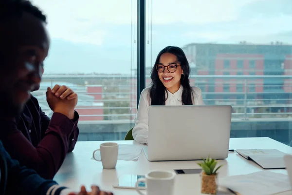 Jovencita sonriente y exitosa sentada con sus colegas multiétnicos en una reunión de negocios corporativos —  Fotos de Stock