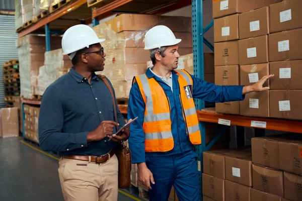 Operaio di fabbrica maschile che mostra magazzino al suo inventario utilizzando tablet digitale in grande magazzino — Foto Stock