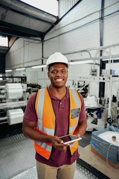 Giovane industriale nel lavoro indossa in piedi con tablet digitale nel magazzino di fabbrica — Foto Stock