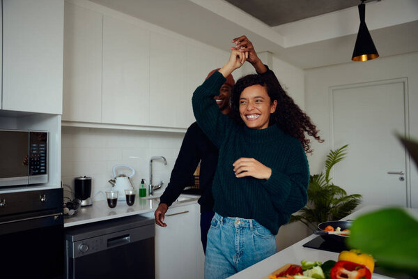 Mixed race couple having fun in the kitchen. Mixed race couple dancing together. High quality photo — Stock Photo, Image
