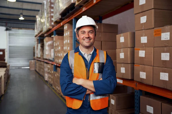 Retrato sonriente de un trabajador de almacén con chaleco protector y sombrero blanco — Foto de Stock