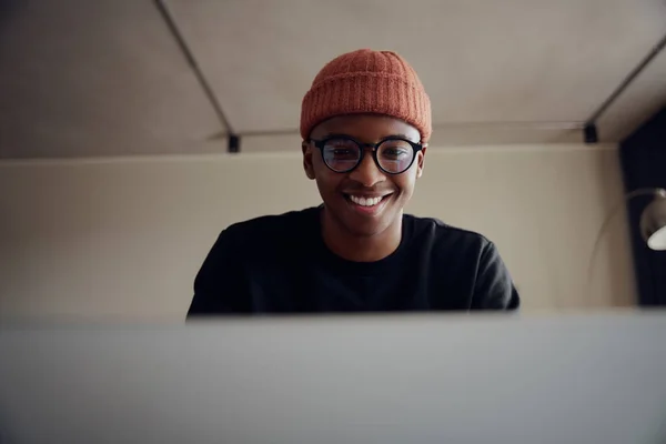 Homem afro-americano trabalhando em casa usando laptop. Homem afro-americano feliz trabalhando em casa com fones de ouvido. Foto de alta qualidade — Fotografia de Stock