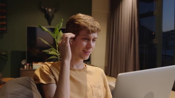 Joven hombre de negocios caucásico trabajando desde casa participando en videollamadas escuchando con auriculares — Vídeos de Stock