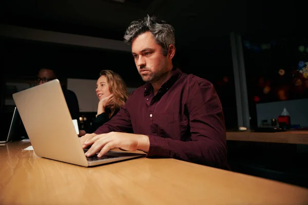 Porträtt av en seriös manlig affärsman upptagen med att arbeta på laptop på skrivbordet på kontoret — Stockfoto