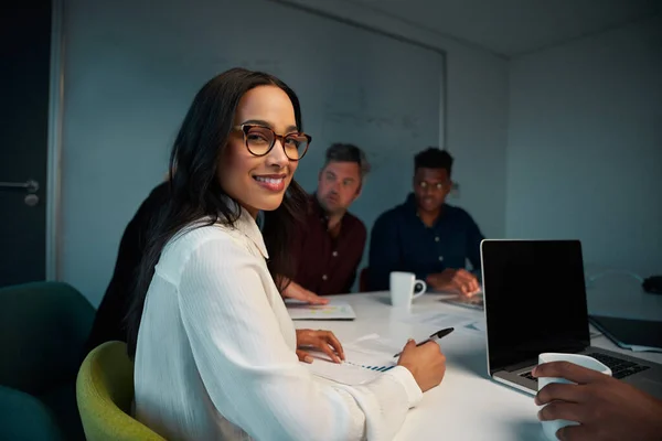 Portrait of young smiling female employee looking at camera while working at workplace — Stockfoto