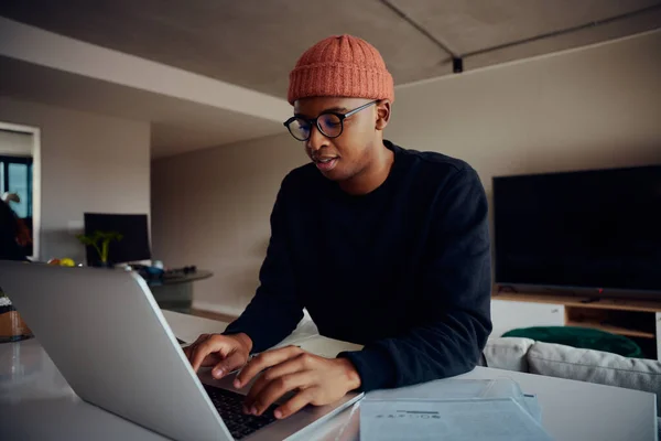 Homem afro-americano trabalhando em casa usando laptop. Homem afro-americano feliz a trabalhar em casa. Foto de alta qualidade — Fotografia de Stock