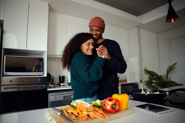 Young, happy mixed race couple holding hands in the kitchen. Mixed race couple dancing together and having fun. High quality photo — Stock Photo, Image