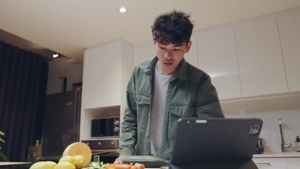 Mixed race young male researching recipe on laptop preparing healthy dinner for partner — Stock Video