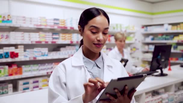 Farmacêutica feminina de raça mista que trabalha em farmácia digitando em tablet digital — Vídeo de Stock