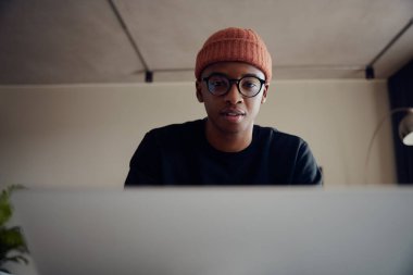 Evde dizüstü bilgisayar kullanarak çalışan Afro-Amerikan erkek. Evde kulaklıkla çalışan mutlu Afrikalı Amerikalı erkek. Yüksek kalite fotoğraf 