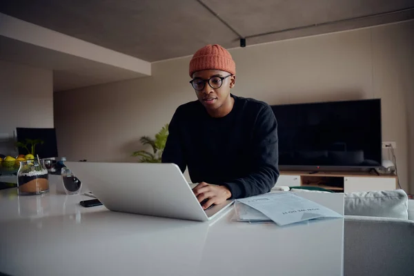 Homme afro-américain travaillant à domicile à l'aide d'un ordinateur portable. Heureux homme afro-américain travaillant à la maison. Photo de haute qualité — Photo