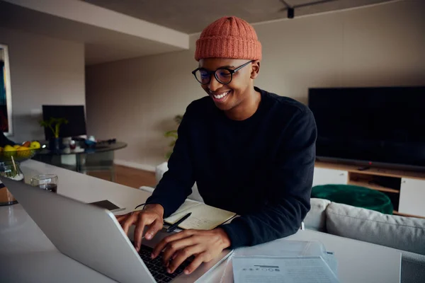 アフリカ系アメリカ人男性はノートパソコンを使って家庭で働いている。家庭で働くアフリカ系アメリカ人の幸せな男性。高品質の写真 — ストック写真