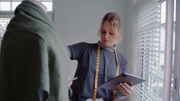 白种人女性时装设计师利用数码平板电脑为女性做服装研究 — 图库视频影像