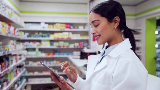 Farmacêutica feminina de raça mista que trabalha em farmácia digitando em tablet digital — Vídeo de Stock