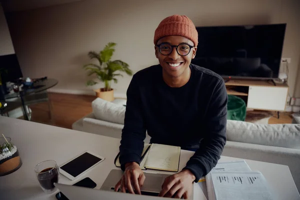 Homem afro-americano trabalhando em casa e navegando em seu laptop. Um afro-americano a escrever notas e a escrever no portátil. Foto de alta qualidade — Fotografia de Stock