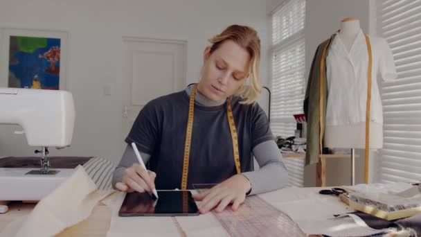 Mujer caucásica diseñadora de moda trabajando en estudio desde casa diseñando vestidos — Vídeo de stock
