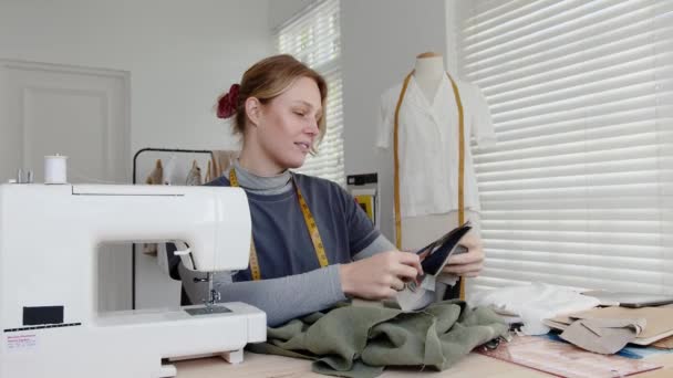 Blanke vrouwelijke jurk ontwerper met behulp van materiaal swabs voor nieuwe jurk ontwerp — Stockvideo