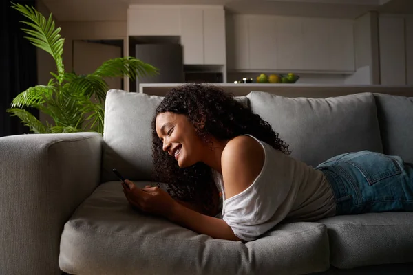 Gemengde ras vrouwelijke student werken vanuit huis sms 'en op cellulaire apparaat — Stockfoto