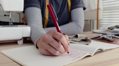 Kadın tasarımcının not defterine yazma ölçümlerini kapat 