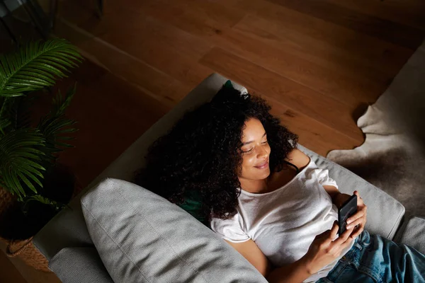 Texting fêmea de raça mista no dispositivo celular enquanto faz intervalo de estudo — Fotografia de Stock
