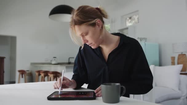 집에서 일하는 코카서스 여대생 이 디지털 태블릿으로 미술 작품을 만들고 있다 — 비디오