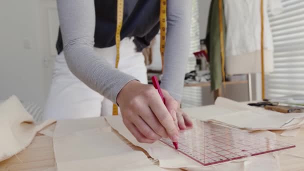 Blanke vrouwelijke mode ontwerper snijden en meten voor nieuwe collectie — Stockvideo