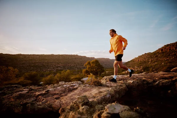 Fitness macho corriendo por sendero rocoso de montaña —  Fotos de Stock