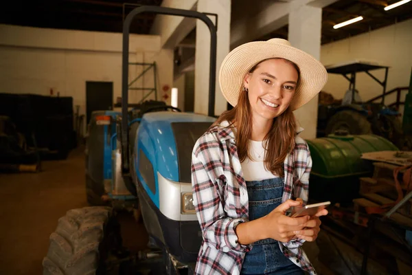 Agriculteur femme caucasienne assis sur tracteur textos sur tablette numérique — Photo